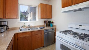 A kitchen with wooden cabinets, a dishwasher, a stove, and a window. - Convenient 2 bedroom, walk to Bart, 10 min to Berkeley (Richmond)