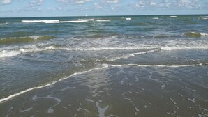 Una playa con olas y cielo despejado.