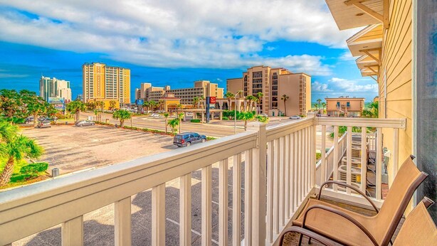 A balcony with a view of a parking lot, buildings, and a clear sky. - Super cute and clean studio (Myrtle Beach)