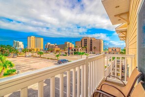 A balcony with a view of a parking lot, buildings, and a clear sky. - Super cute and clean studio (Myrtle Beach)