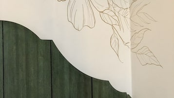 A wall with a floral design and a wooden panel.