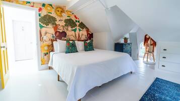 Un dormitorio con una cama grande, un mural en la pared, una lámpara en el techo y una ventana.