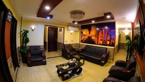 A spacious lobby with a modern design, featuring a large seating area with sofas and chairs, a chandelier, and a large wall mural. - Cairo Hotel (Cairo)