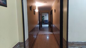 A long, narrow hallway with wooden flooring and black-framed doors. - Cairo Hotel (Cairo)