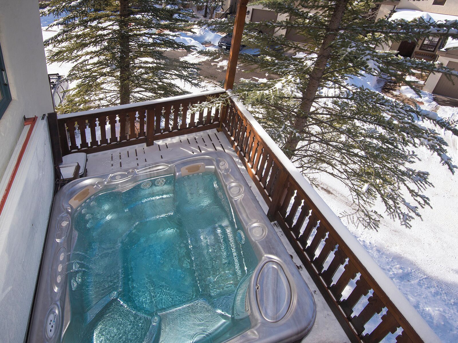 Een hottub op een balkon met besneeuwde omgeving.