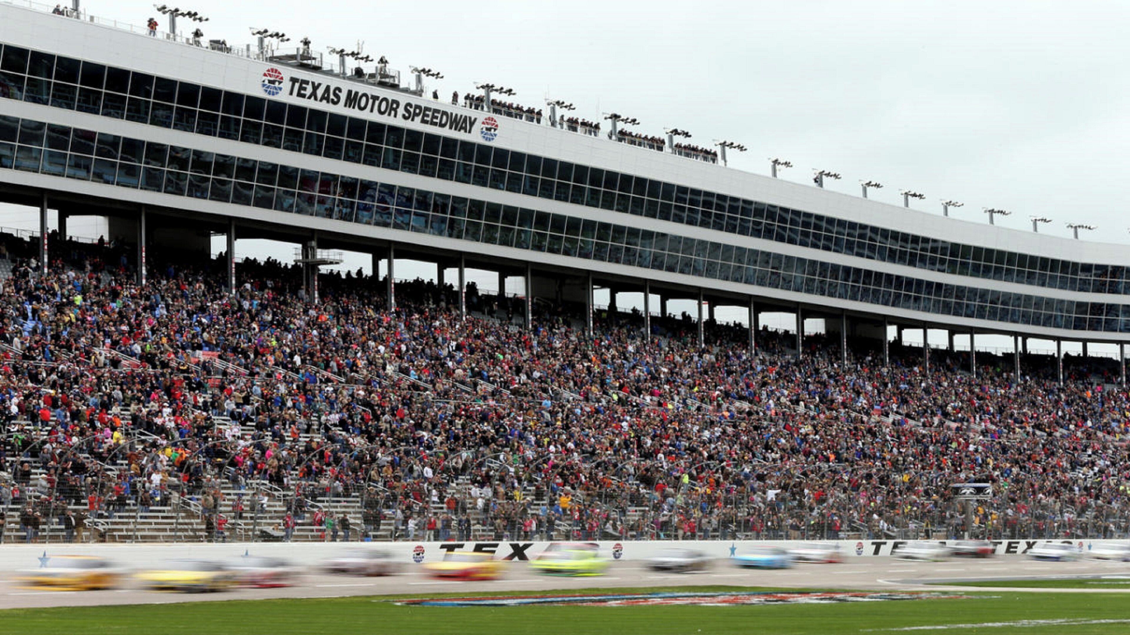 A large stadium with a covered spectator area and a prominent 'Texas Motor Speedway' sign.