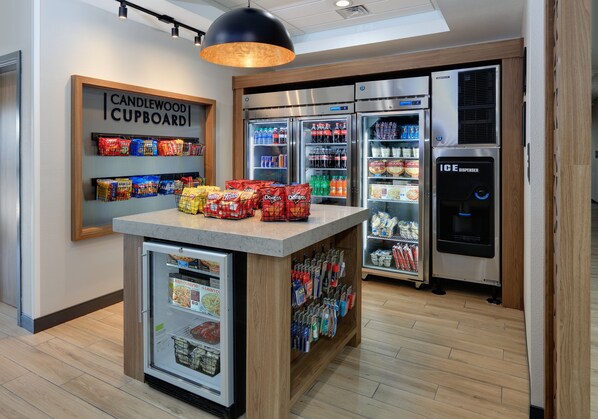 A kitchenette with a refrigerator, a freezer, a microwave, and a coffee machine.