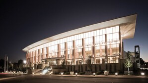 Un bâtiment moderne doté d’une façade incurvée, de grandes fenêtres et d’un toit plat.