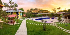 A pool area with a circular design, surrounded by a paved walkway and a covered seating area. - Ecohotel La Casona (Pereira)