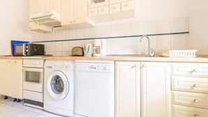 A compact kitchen with a washing machine, microwave, toaster, and a sink. - near Dubrovnik City Walls (Dubrovnik)
