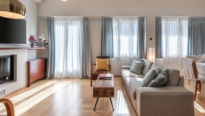 Een moderne woonkamer met een bank, een bijzettafeltje en een televisie.