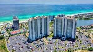 A high-rise hotel with multiple floors, a parking lot, and a view of the ocean. - special, complete and fun (Miramar Beach)