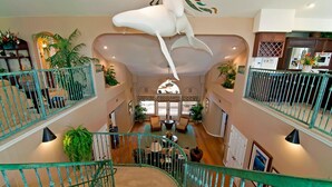 A multi-level interior with a central staircase, multiple floors, and a ceiling sculpture.