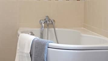 Una bañera con una toalla blanca y una azul.