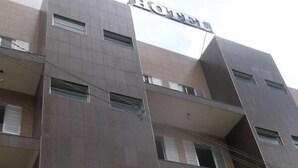 A modern hotel building with a prominent 'HOTEL' sign at the top.
