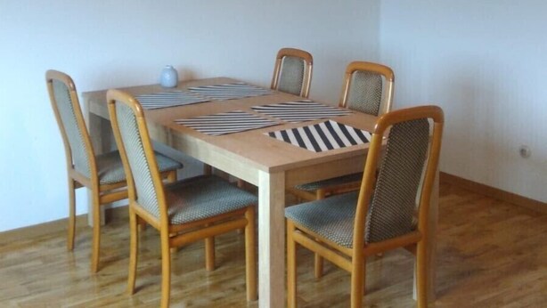 A dining area with a wooden table and chairs, a ceiling light fixture, and a wall-mounted picture. - 'Klein und Fein' Garbenteich (Pohlheim)