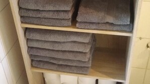 A wooden shelf with folded towels and toilet paper. - 'Klein und Fein' Garbenteich (Pohlheim)