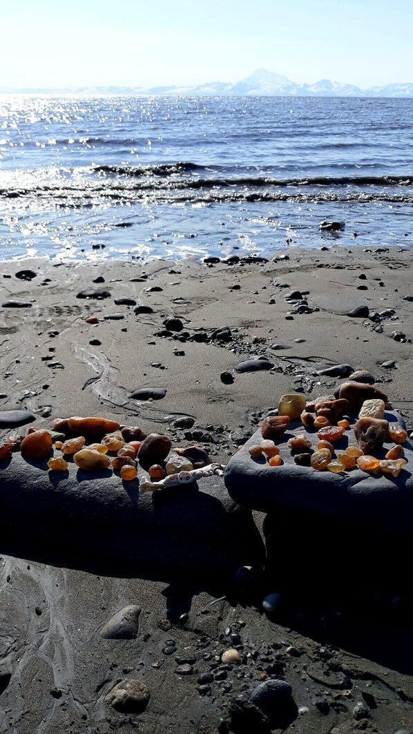 Enjoy the serene beach atmosphere with gentle waves and scenic views of the surrounding mountains.