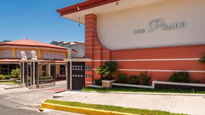 A hotel entrance with a prominent sign reading "THE PRADO". - Prado Inn & Suites (San José)