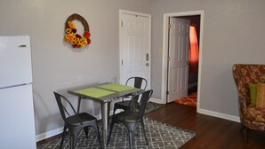 Un comedor con mesa, sillas y un refrigerador.