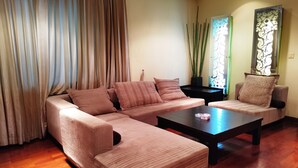 Una sala de estar con un sofá modular, una mesa de centro y un adorno de pared estampado.