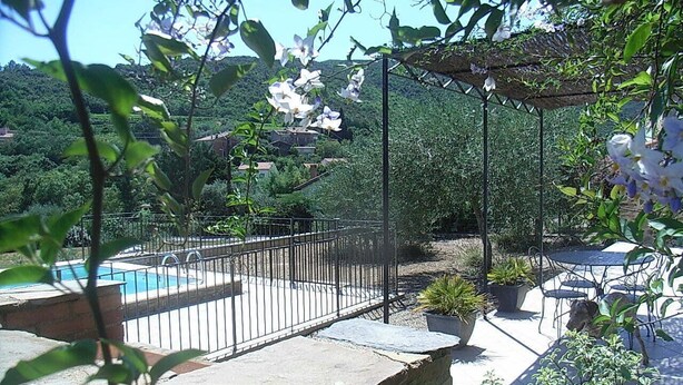 Ein Garten mit Swimmingpool, einer Pergola und Gartenmöbeln.