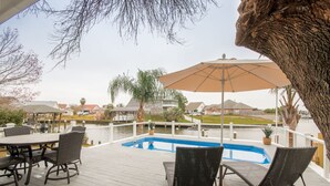 Una terrassa amb piscina, mobles d'exterior i vista a una zona residencial.