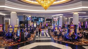 A casino with multiple gaming machines, a grand chandelier, and a central walkway. - The Louie Hotel New Orleans, Belvilla District 6 Formerly Sonder (New Orleans)