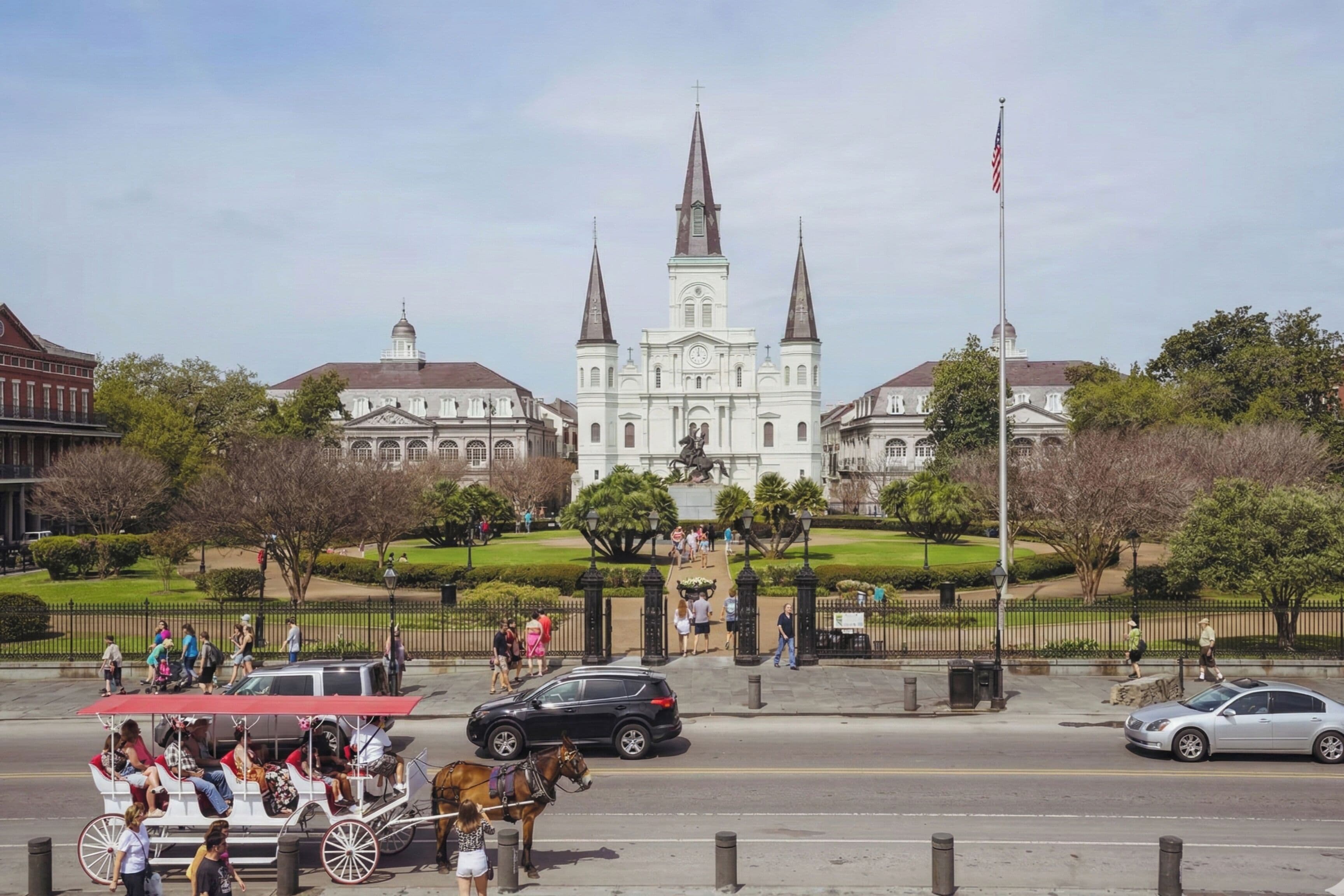 A historic building with a prominent steeple and a statue in front.