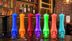 A bar with colorful skull-shaped candles and a shelf with liquor bottles. - The Louie Hotel New Orleans, Belvilla District 6 Formerly Sonder (New Orleans)