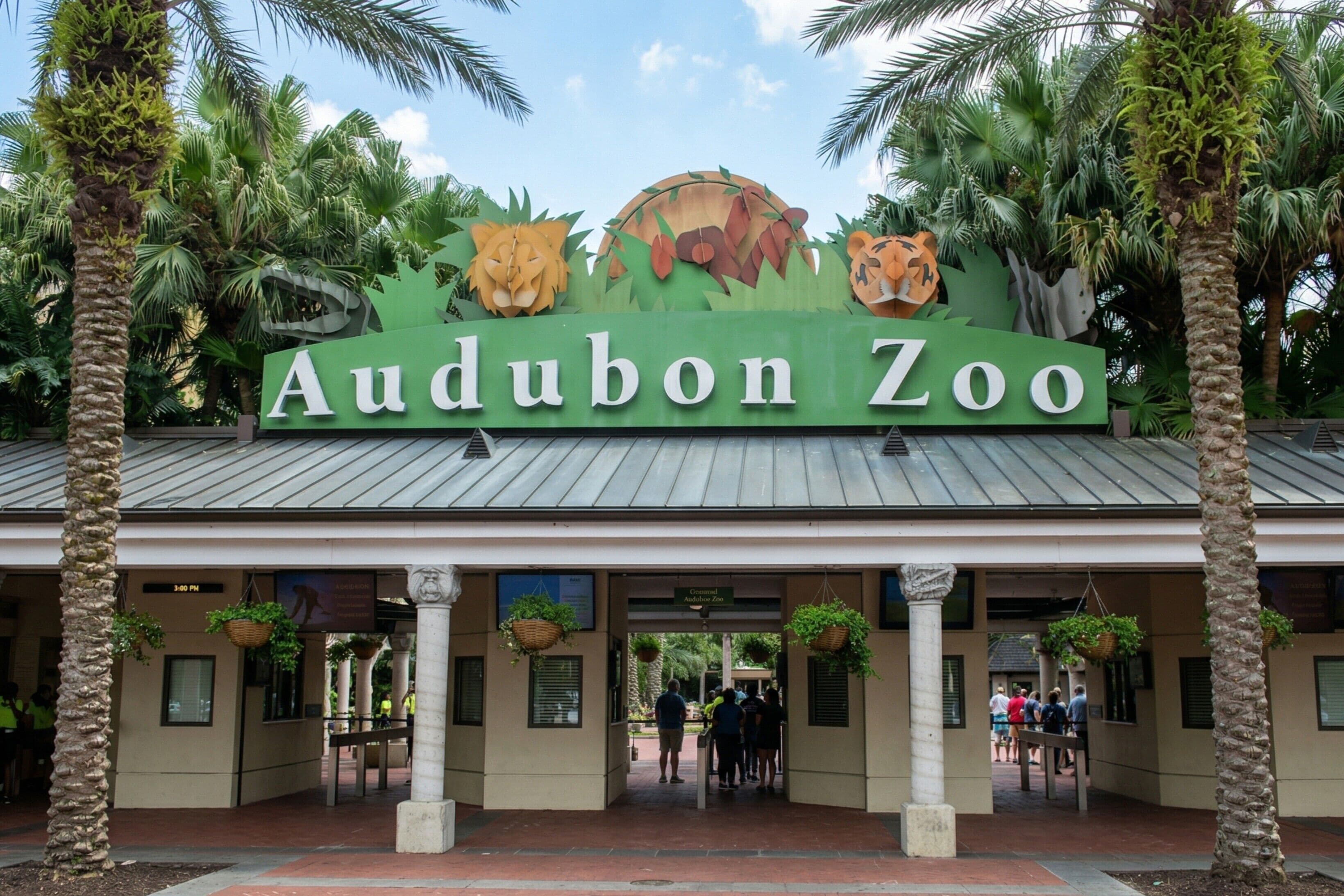 L’entrée du zoo d’Audubon, avec une enseigne ornée de sculptures d’animaux et de palmiers.