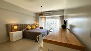 A modern bedroom with a bed, bedside tables, a desk, and a view of the city. - Soho Rentals (Buenos Aires)