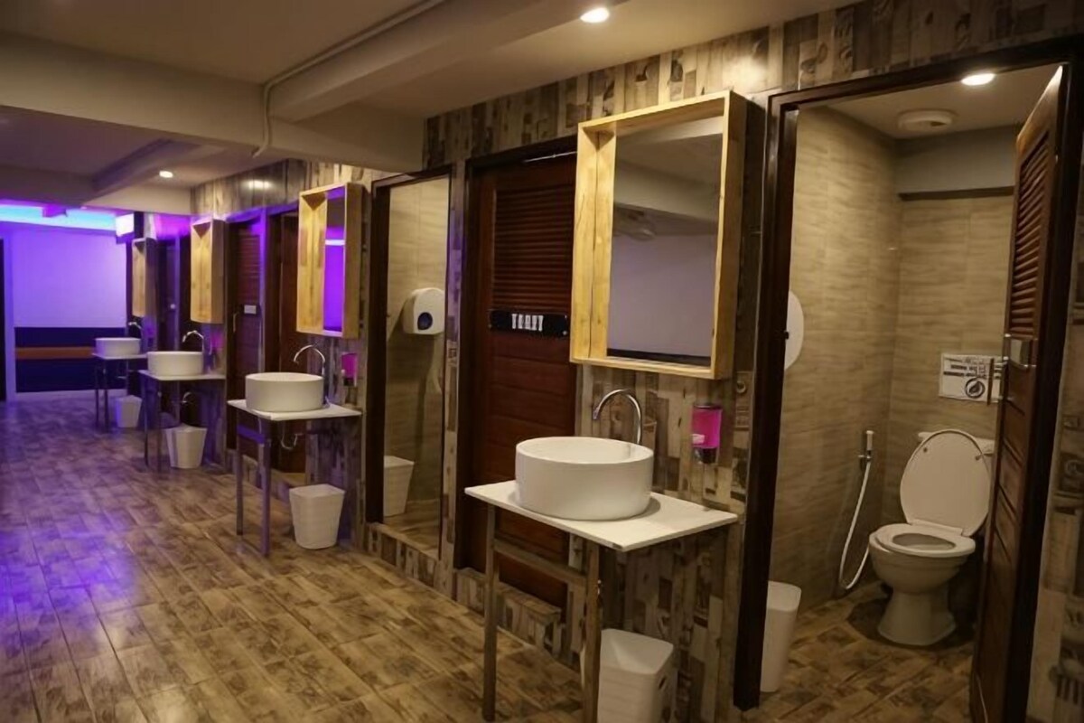 A hotel bathroom with multiple sinks, mirrors, and a shower area.