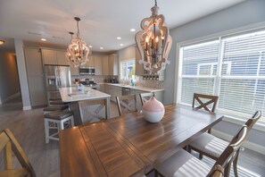 A modern kitchen with a central island, stainless steel appliances, and pendant lighting. - Family fun-large home, beach, pools, pet friendly! (Long Neck)