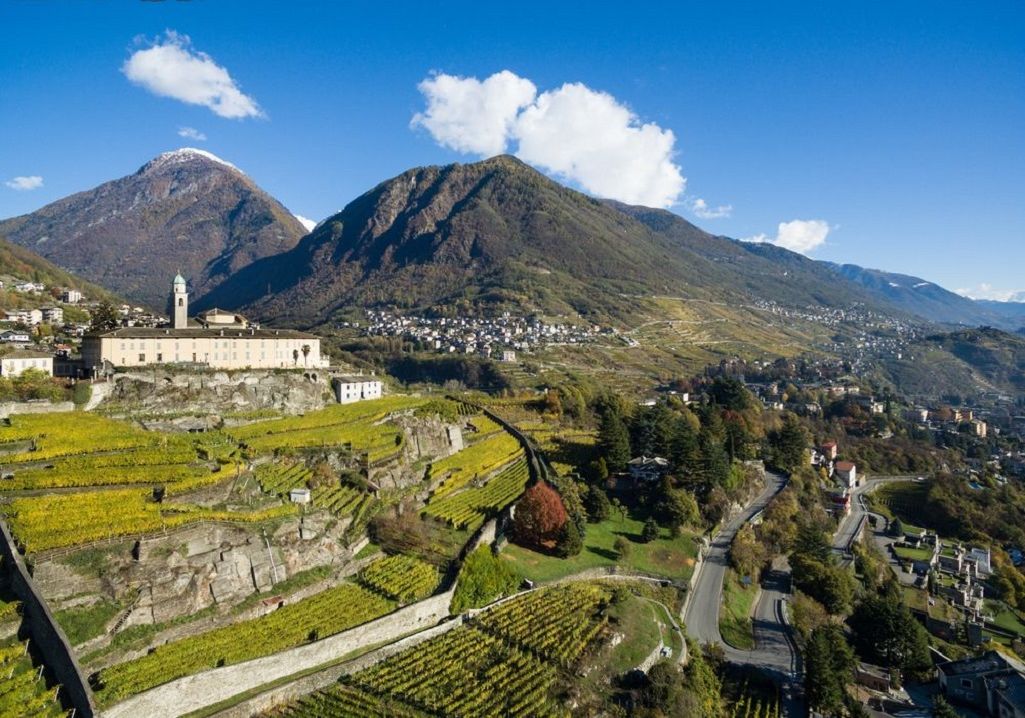 Un paysage montagneux, avec une église imposante et des immeubles d’habitation.