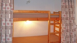 A bunk bed with a wooden frame and a mattress.