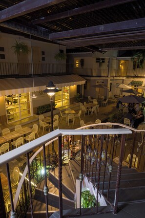 Une terrasse sur le toit avec des sièges en plein air, un escalier et un espace bar.