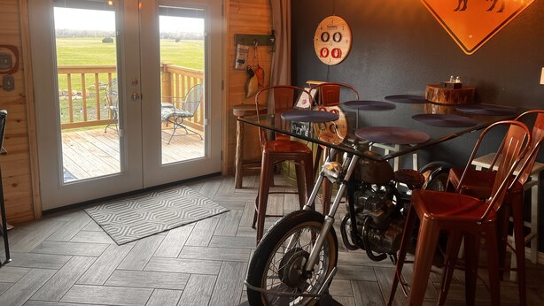Een eetgedeelte met een motor, houten wanden en een uitzicht door de glazen deuren.