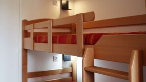 A bunk bed with a wooden frame and red bedding. - Ski-in/ski-out apartment for 6, balcony, near daycare (Les Orres)