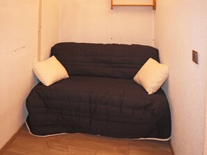 Cozy space with a sofa bed, pillows, and a light switch.