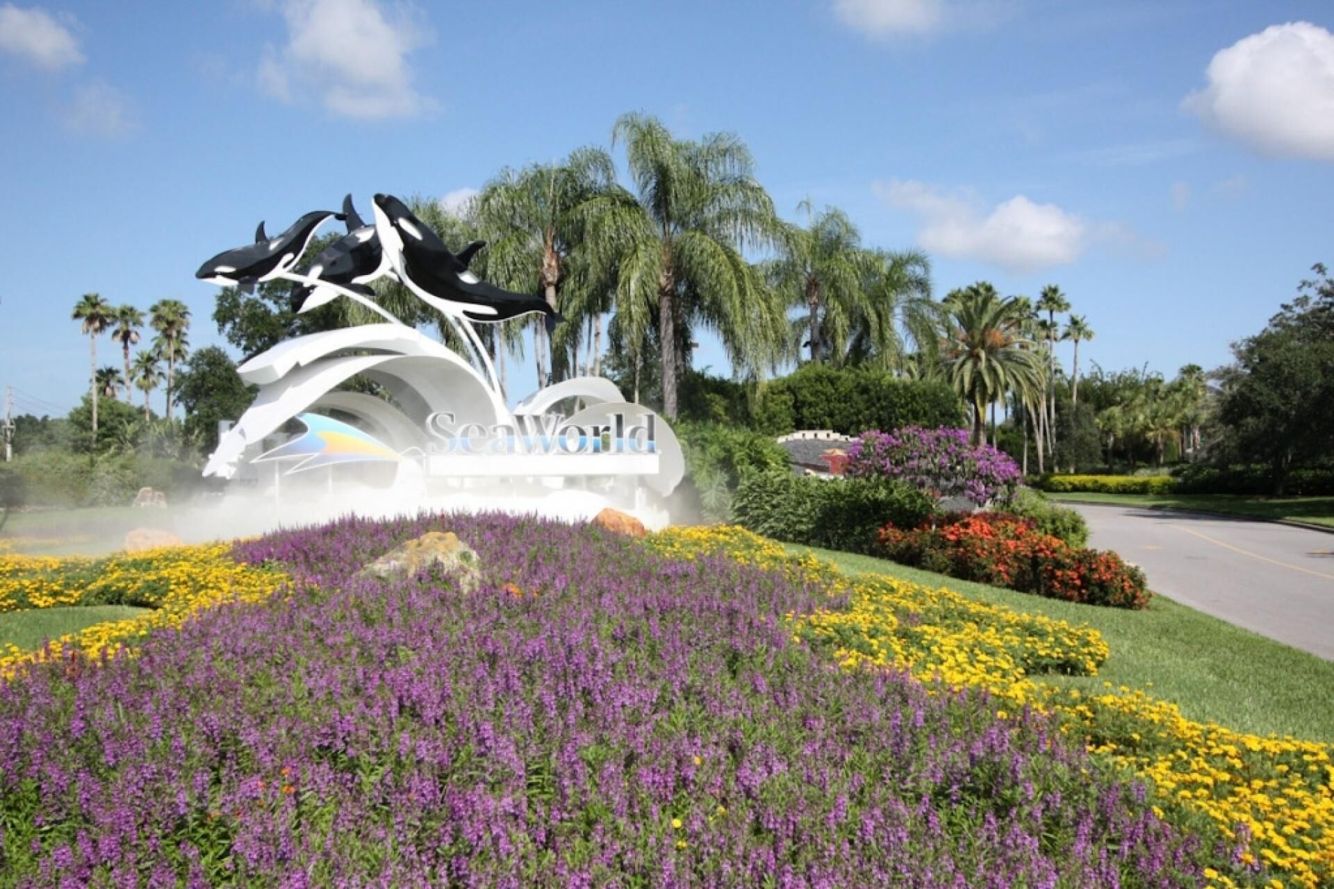 Un espace paysager agrémenté d’une grande sculpture de dauphins et du mot « SeaWorld » inscrit au centre.