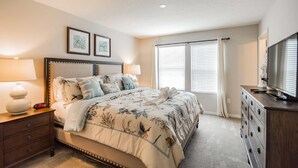 A bedroom with a large bed, two bedside lamps, a dresser, and a television on a dresser. - 5131 Compass Bay (Kissimmee)
