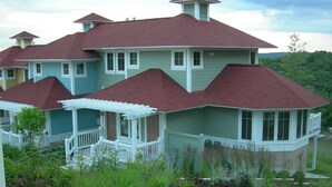 A large, multi-story house with a red roof and a wrap-around porch. - Ski In/Ski Out Mountain Top Condo at Crystal Mountain (Thompsonville)