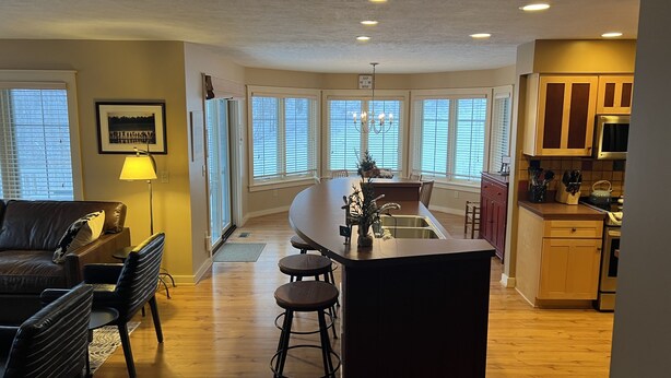 A spacious kitchen with a central island, wooden flooring, and large windows. - Ski In/Ski Out Mountain Top Condo at Crystal Mountain (Thompsonville)