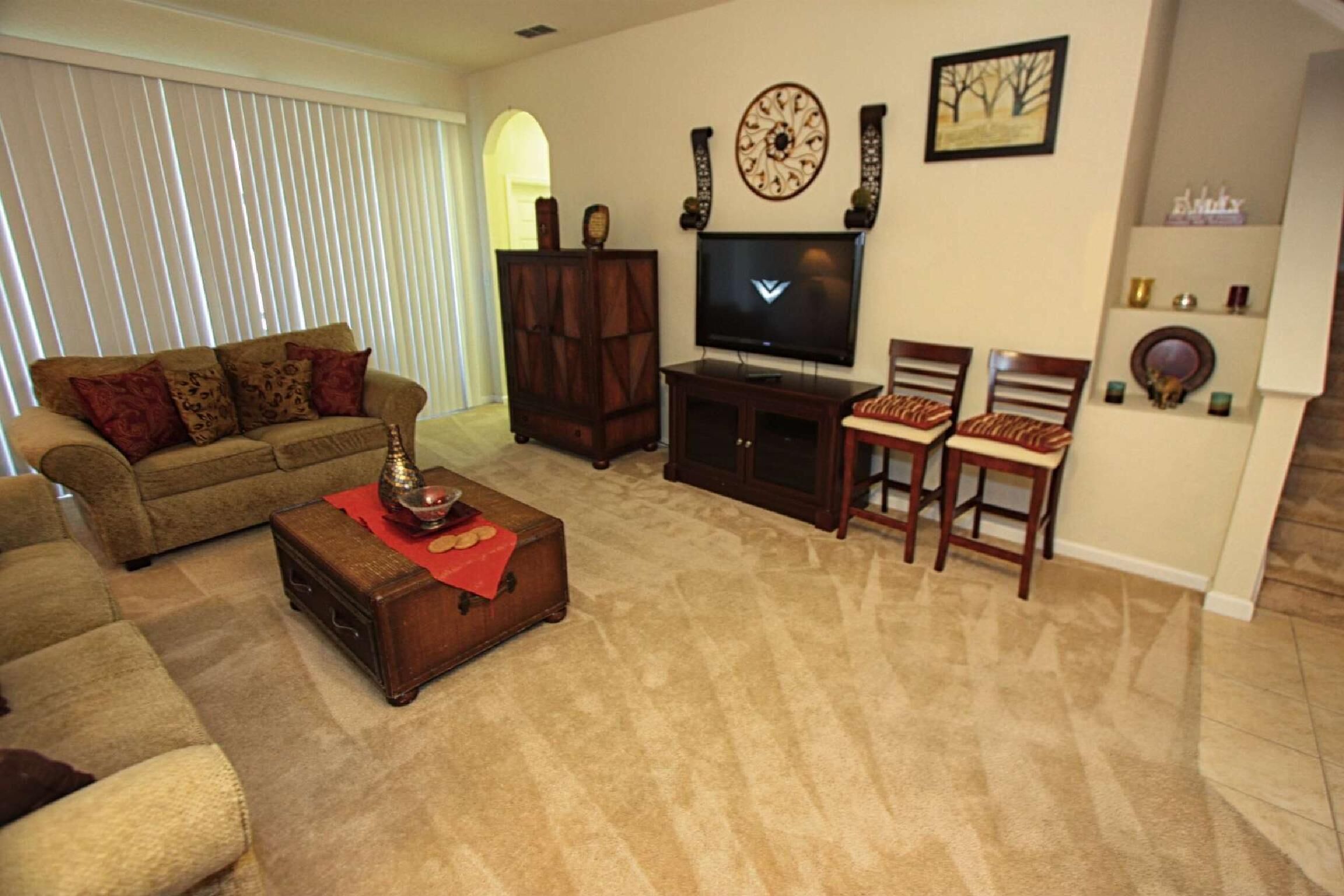 Una sala de estar con sofá, mesa de centro, televisor y chimenea.