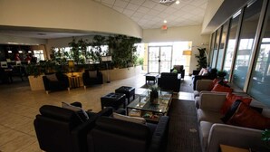 A spacious lobby with a curved seating area, a reception desk, and a large window providing a view of the outside. - 3081 Encantada (Kissimmee)