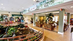 A spacious lobby with a central water feature, comfortable seating areas, and a marketplace in the background. - 710 Bahama Bay (Davenport)