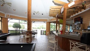 A pool table with chairs, a bar area, and a view of the outdoors. - 710 Bahama Bay (Davenport)