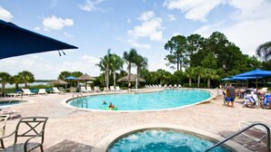 A swimming pool area with lounge chairs, umbrellas, and a small hot tub. - 710 Bahama Bay (Davenport)
