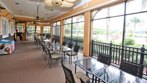 A spacious indoor dining area with large windows, ceiling fans, and a view of the outdoor area. - 710 Bahama Bay (Davenport)